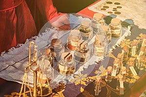 Ancient shop of a seller of spices at the historic fair. The hands of the seller of spice on the retro market