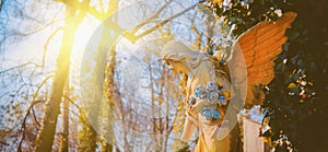 An ancient statue of angel in sunlight. Horizontal image