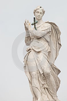 Ancient statue of beautiful praying Saint Angel with sword in her chest at the top of Arsenal in Venice, Italy, details, closeup