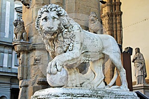 Ancient statue of a lion in Piazza della Signoria, sculpture that depicts a lion with a sphere under one paw