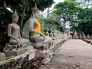 Ancient statues of meditating buddha sitting, at Wat Yai Chaimongkol in Ayutthaya, Thailand