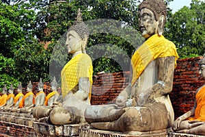 Ancient statues of meditating buddha sitting, at Wat Yai Chaimongkol old temple in Ayutthaya, Thailand