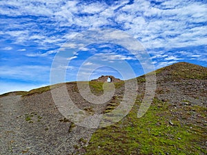 Ancient stone arch on top of empty hill in Wales