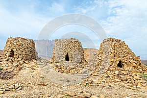 Ancient stone beehive tombs with Jebel Misht mountain in the background, archaeological site near al-Ayn, sultanate Oman