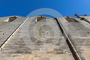 Ancient stone brick wall with gutter and clear blue sky in the b