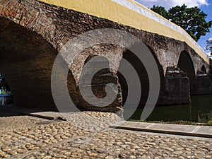 Ancient stone bridge crossing a river, cobblestone street, medieval city, photo