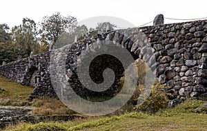 Ancient stone bridge in deep forest landscape.