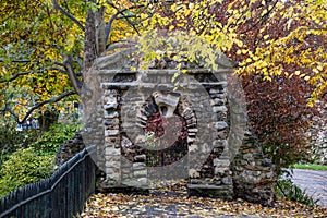 Ancient Stone built archway in a park with trees and shrubbery