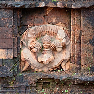 Ancient stone carving on the wall of temple in My Son Sanctuary