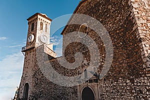 ancient stone church with clock tower at old european city, Cannes, France