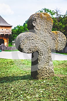 Ancient stone cross with rays round shape