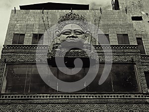 Ancient stone face adorns old building facade.