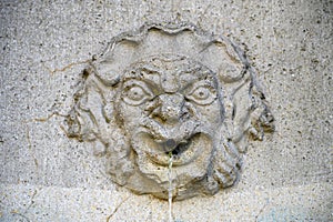 An ancient stone face of a  fountain