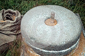 The ancient stone hand mill with grain