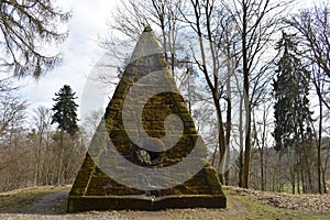 Ancient stone pyramid with moss in the forest on the way to the World Cultural Heritage Herkules in Kassel, WilhelmshÃ¶he, Germany