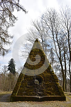 Ancient stone pyramid with moss in the forest on the way to the World Cultural Heritage Herkules in Kassel, WilhelmshÃ¶he, Germany
