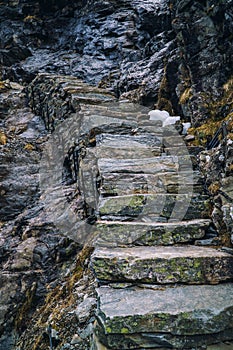 Ancient stone stairs going up on black rock, mountain stairway. Norway, Trolls road, Trollstigen.