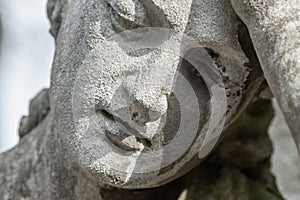 Ancient stone statue of sad man on tomb as a symbol of death, depression, pain and sorrow