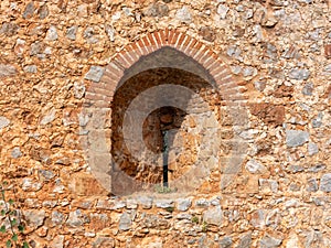 An ancient stone wall of Alanya fortress with an arched window