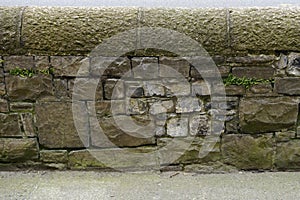 Ancient stone wall capped with tooled blocks