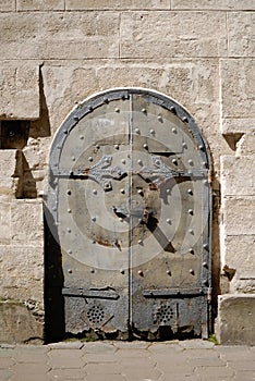 Ancient stone wall with metal forged door