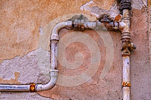 Ancient stone wall and metal water pipes