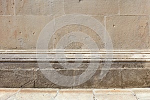 Ancient stone wall with molding and floor background in sunlight