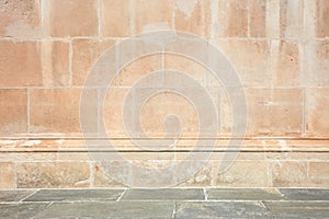 Ancient stone wall with molding and floor background in sunlight