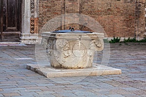 Ancient stone well for rain water in a square in Venice