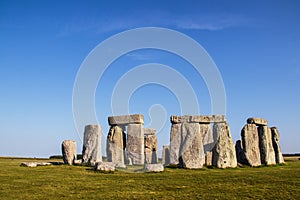 Ancient Stonehenge - standing rocks - in Great Britain under a beautiful blue sky on a sunny day with contrasting shadows