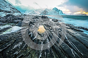 Ancient stones on the shores of cold Norwegian Sea at evening time. Lofoten islands. Beautiful Norway landscape.