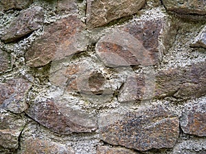 Ancient stonework. The stones are reinforced with old mortar. Uneven masonry ancient wall