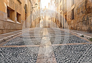 Ancient street with gray pavement bridge of ancient Spain city Tarragona on sunny day