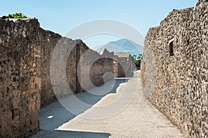 Ancient street with Mount Vesuvius in the background, in the ancient town of Pompeii, Italy