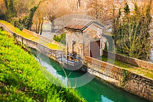 ancient structure of the river lock along the canal surrounded by thick vegetation