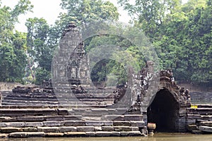 Ancient temple in Angkor Wat complex. Ancient stone temple Neak Pean in green tropical landscape.