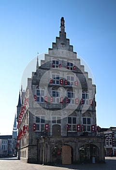 Ancient town hall building of the city Gouda in the Netherlands on the market square with blue sky