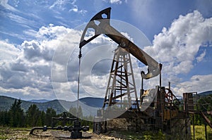 Ancient traditional classical oil pumps of Ukrainian oilmen in the Carpathians in the background of mountains