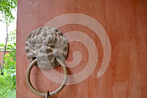 Ancient traditional red wooden door and metal lion door ring in Bingling Temple Lanzhou Gansu, China