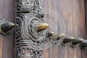 Ancient traditional wooden carved door with ornaments and bronze spike in Stone Town on island Zanzibar, Tanzania, East Africa