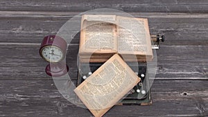 Ancient typewriter and old Bible book on wooden background