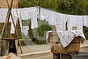 Ancient vat of laundry, brazier and old underwear and sheets hanging to dry