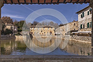 The ancient village of Bagno Vignoni, Siena, Italy, framed by the wall of the thermal pool