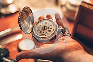 Ancient vintage pocket clock in man hand