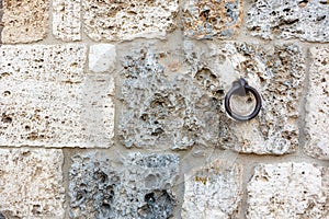 Ancient wall with rusted iron hitching ring