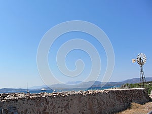 Ancient wall and windmill with seascape