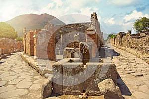 Ancient water well in Pompeii on Mount Vesuvius background, Campania, Italy