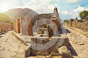 Ancient water well in Pompeii on Mount Vesuvius background, Campania, Italy photo