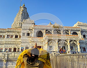 ancient white marble architecture with devotee offering salutation at dusk from flat angle