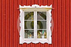 Ancient white window in a red wooden Swedish house